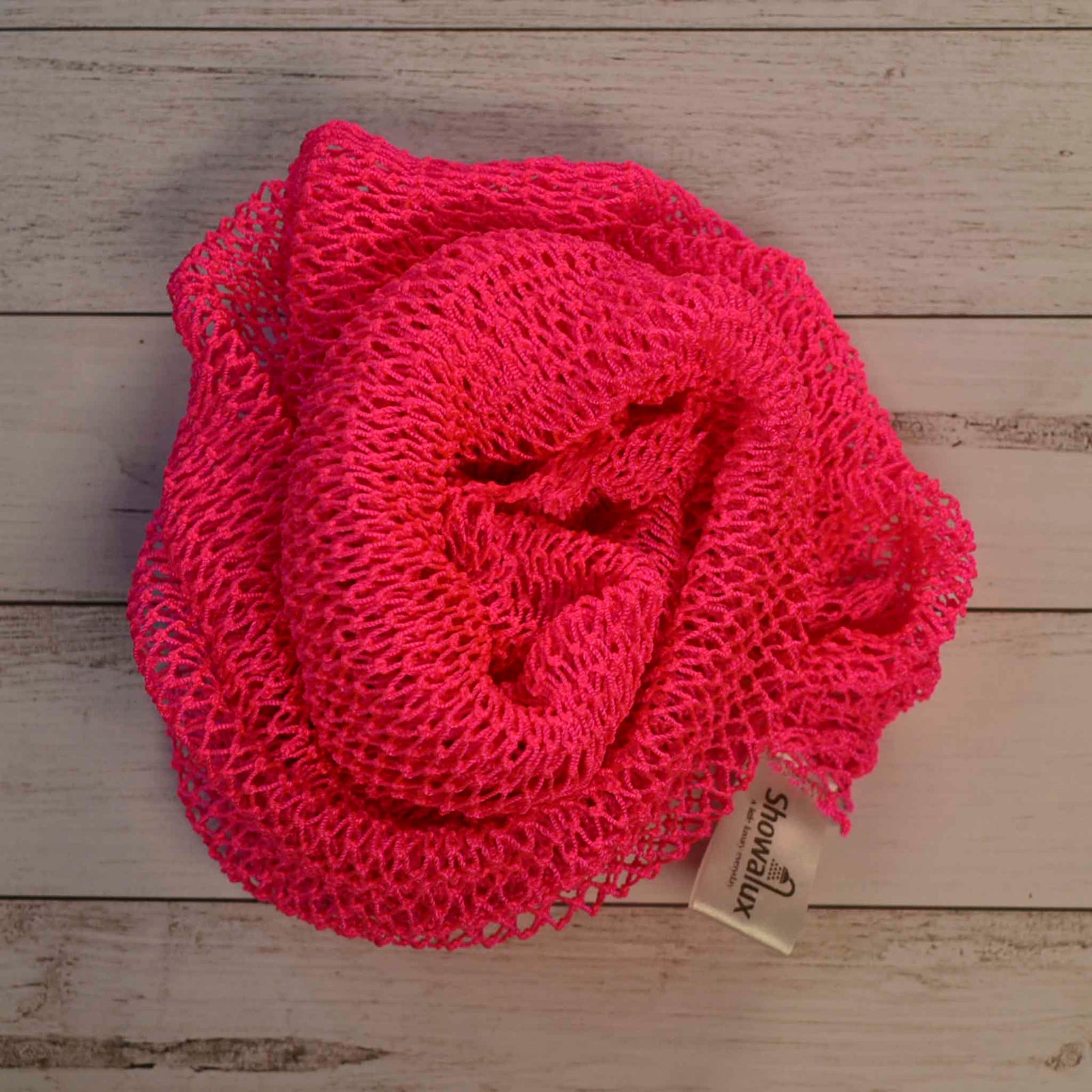 A coil of African Net Sponge coloured Bright Pink on a white background