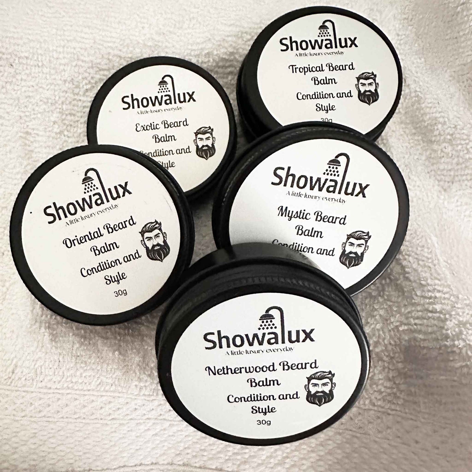 Showalux beard balm containers on a textured surface