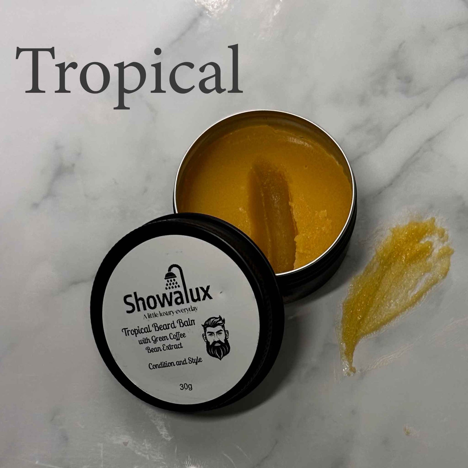 Showalux Tropical Beard Balm container on a marble surface with 'Tropical' text above.