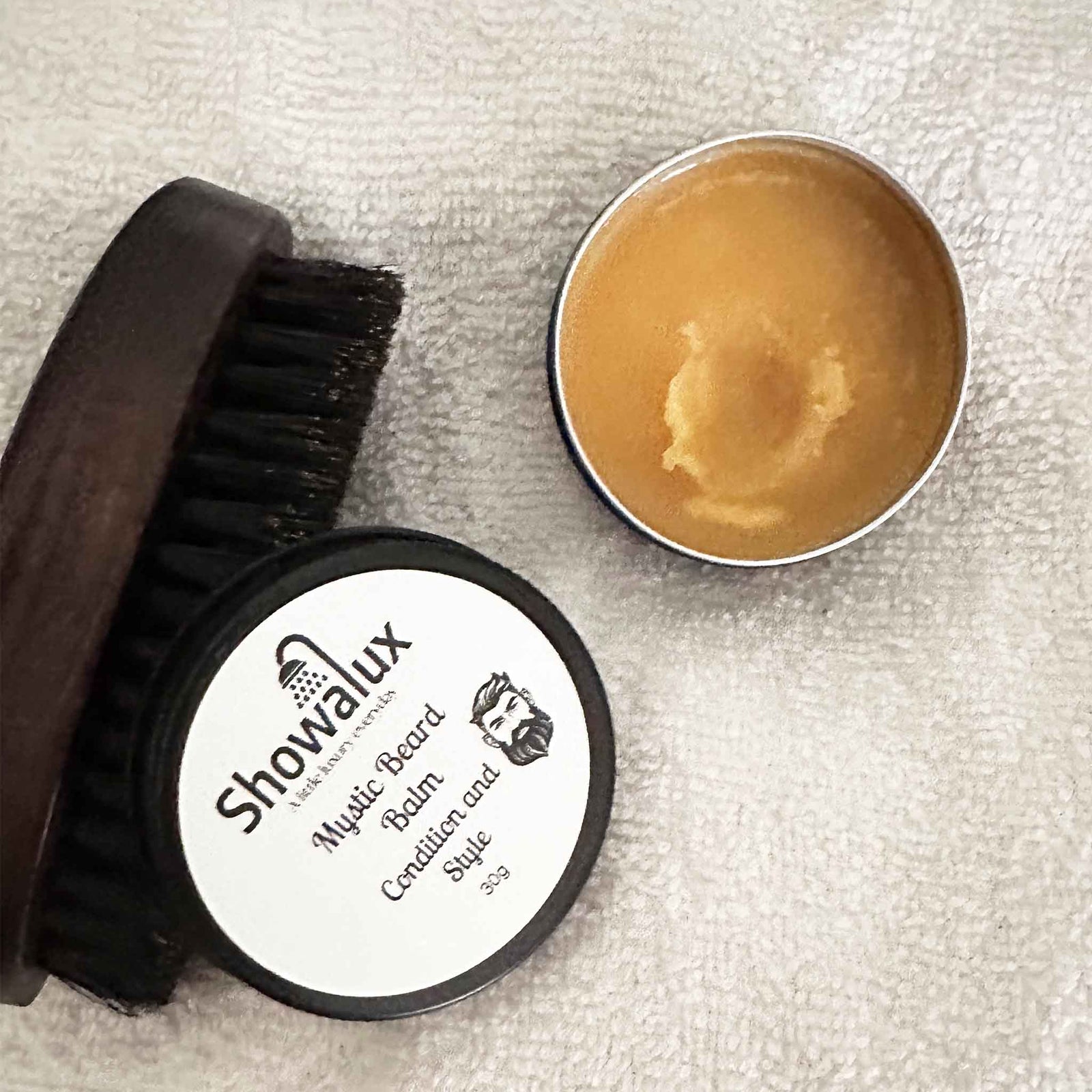 Showalux beard balm and brush on a textured surface