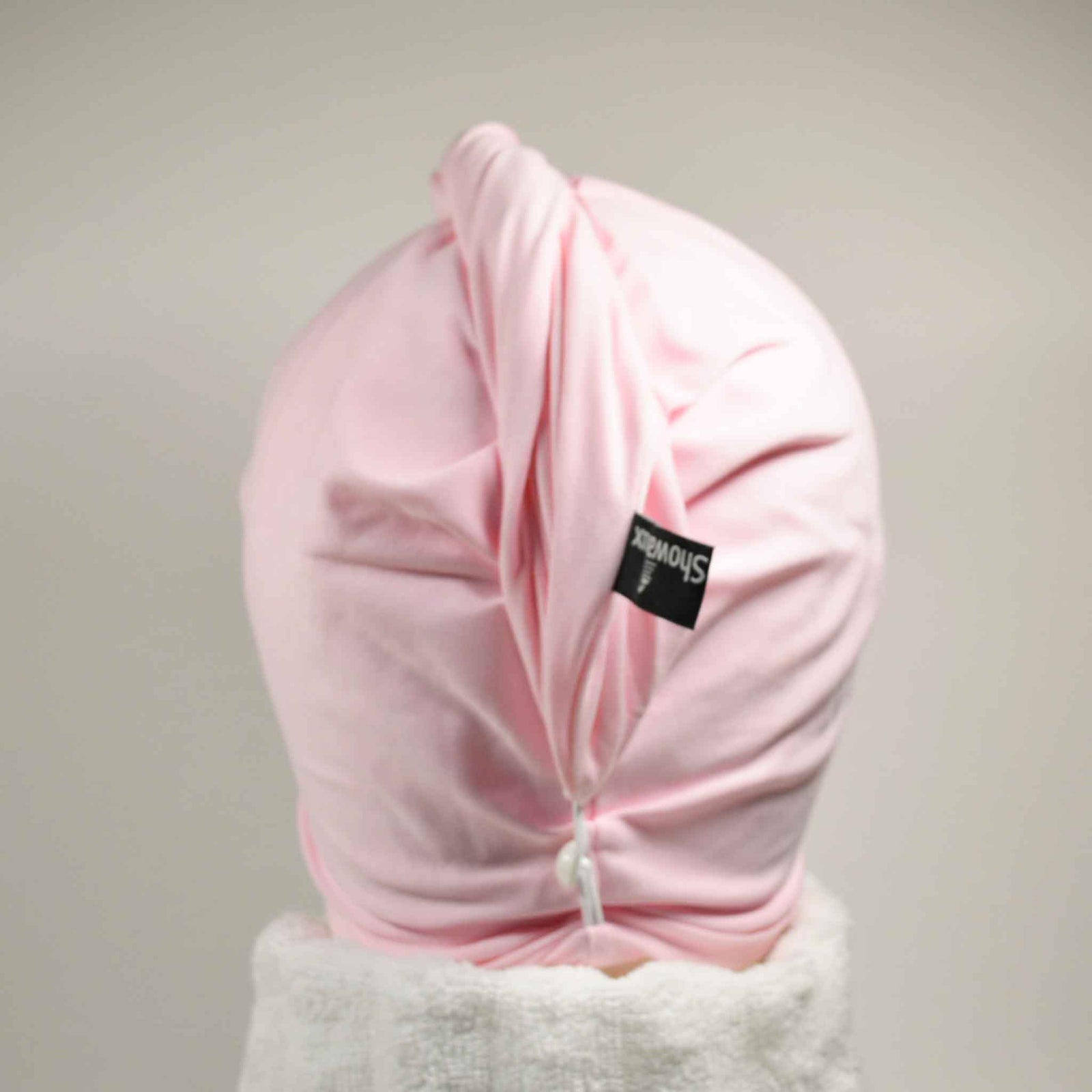 Showing wearing the pink hair wrap with white towel round the neck on a white background