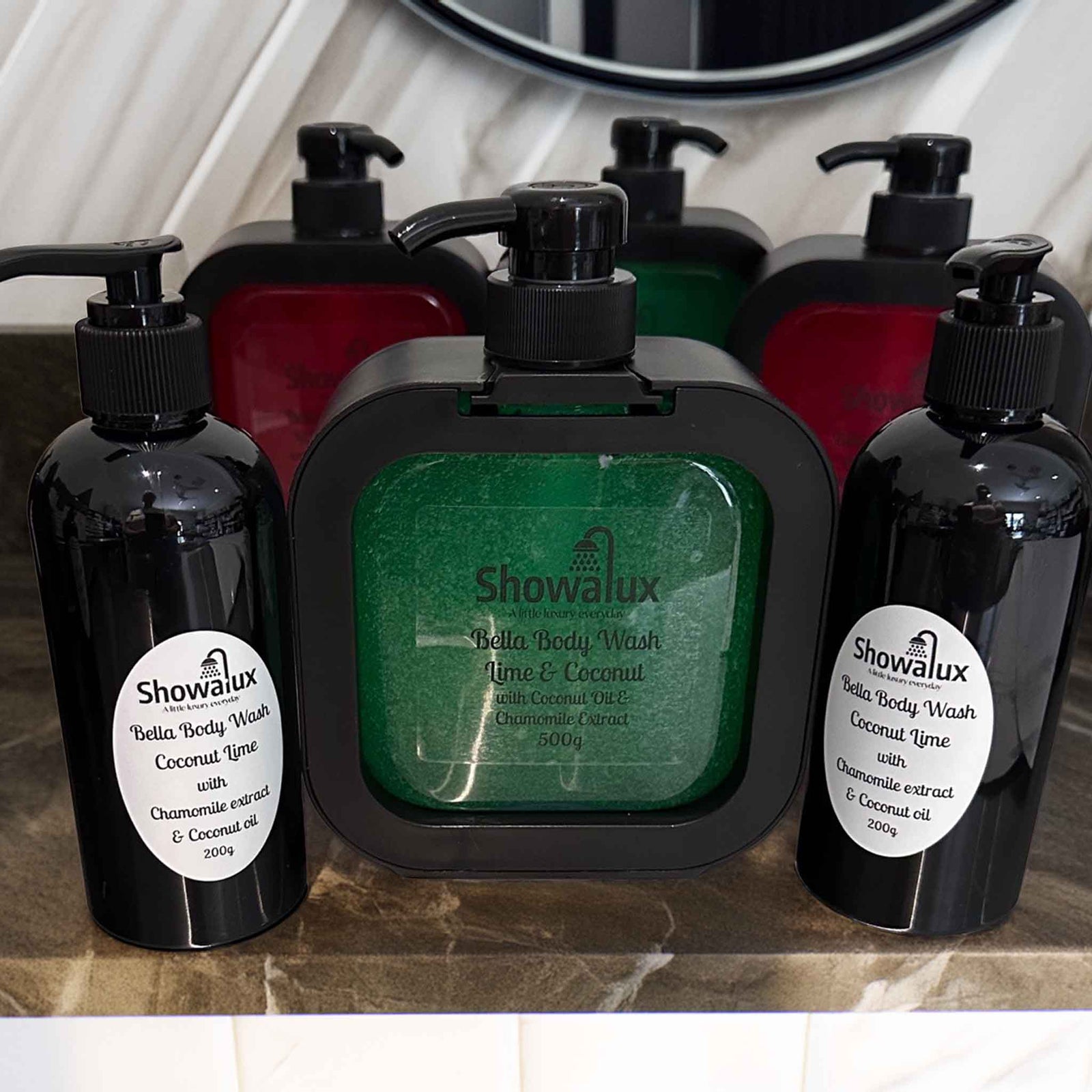 Showalux Bella Body Wash bottles with a green soap on a marble surface.