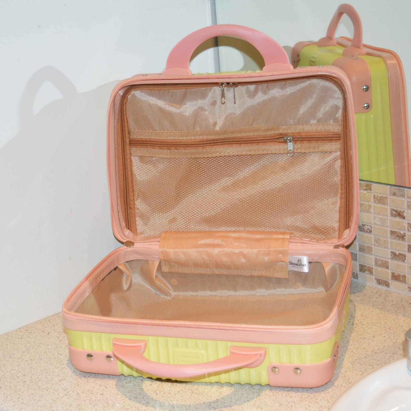 Cream suitcase style bag with pink corners and handles, open on a bench