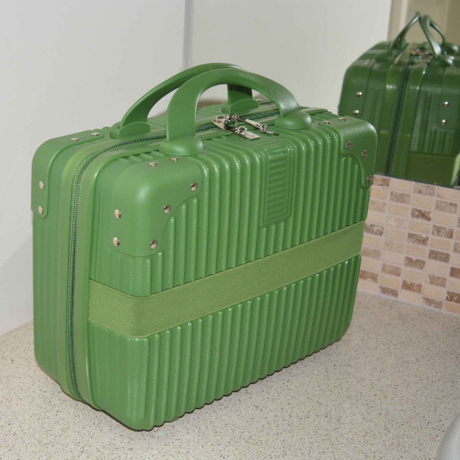 Suitcase Style Toiletry Bag closed and standing up on a bathroom bench in Green