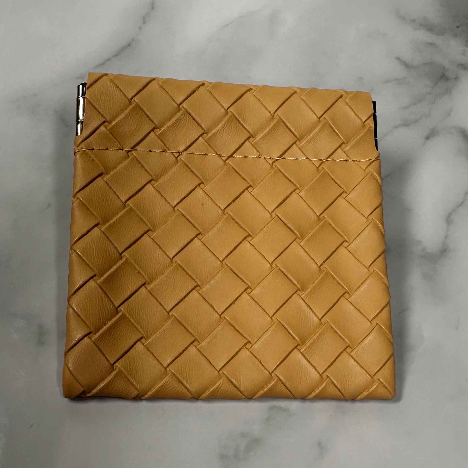 Tan Showalux woven pouch on a marble surface