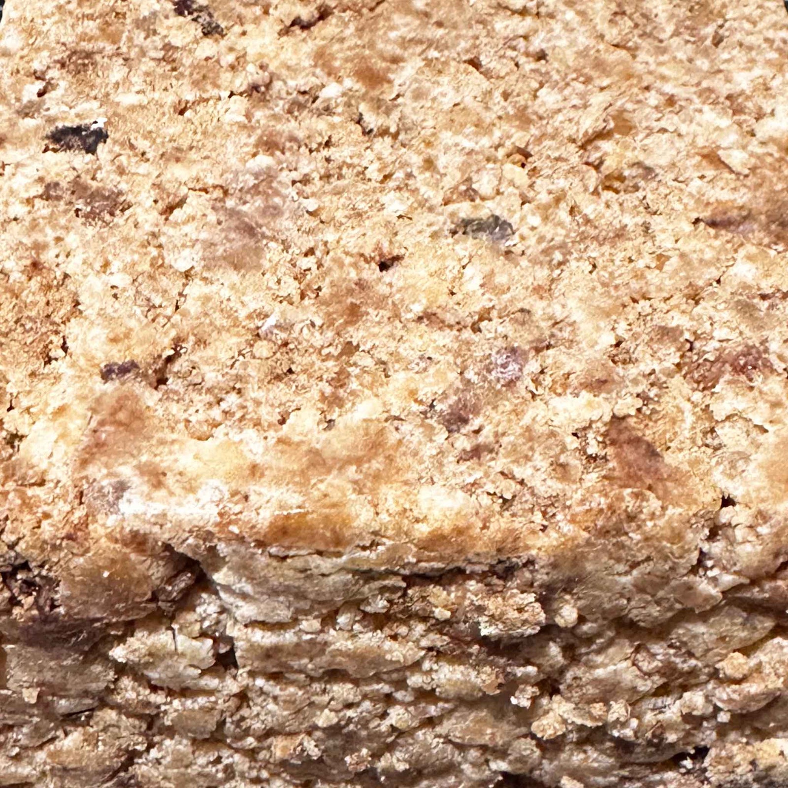 Slice of crumbly black soap on a marble surface