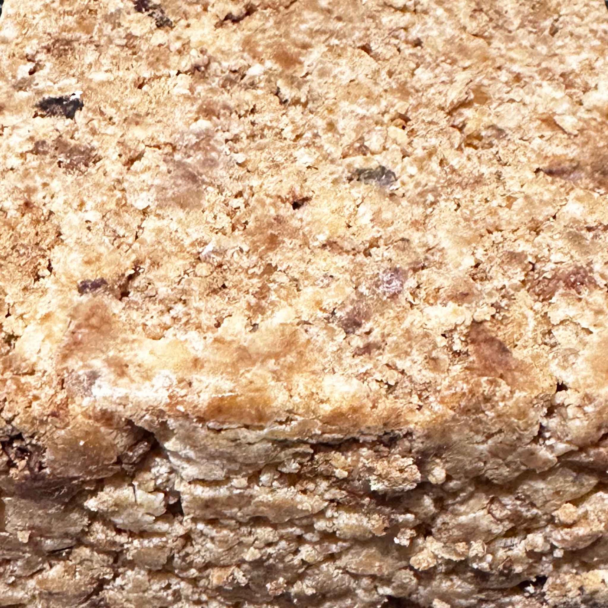 Slice of crumbly black soap on a marble surface