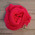 A coil of African Net Sponge coloured Bright Pink on a white background