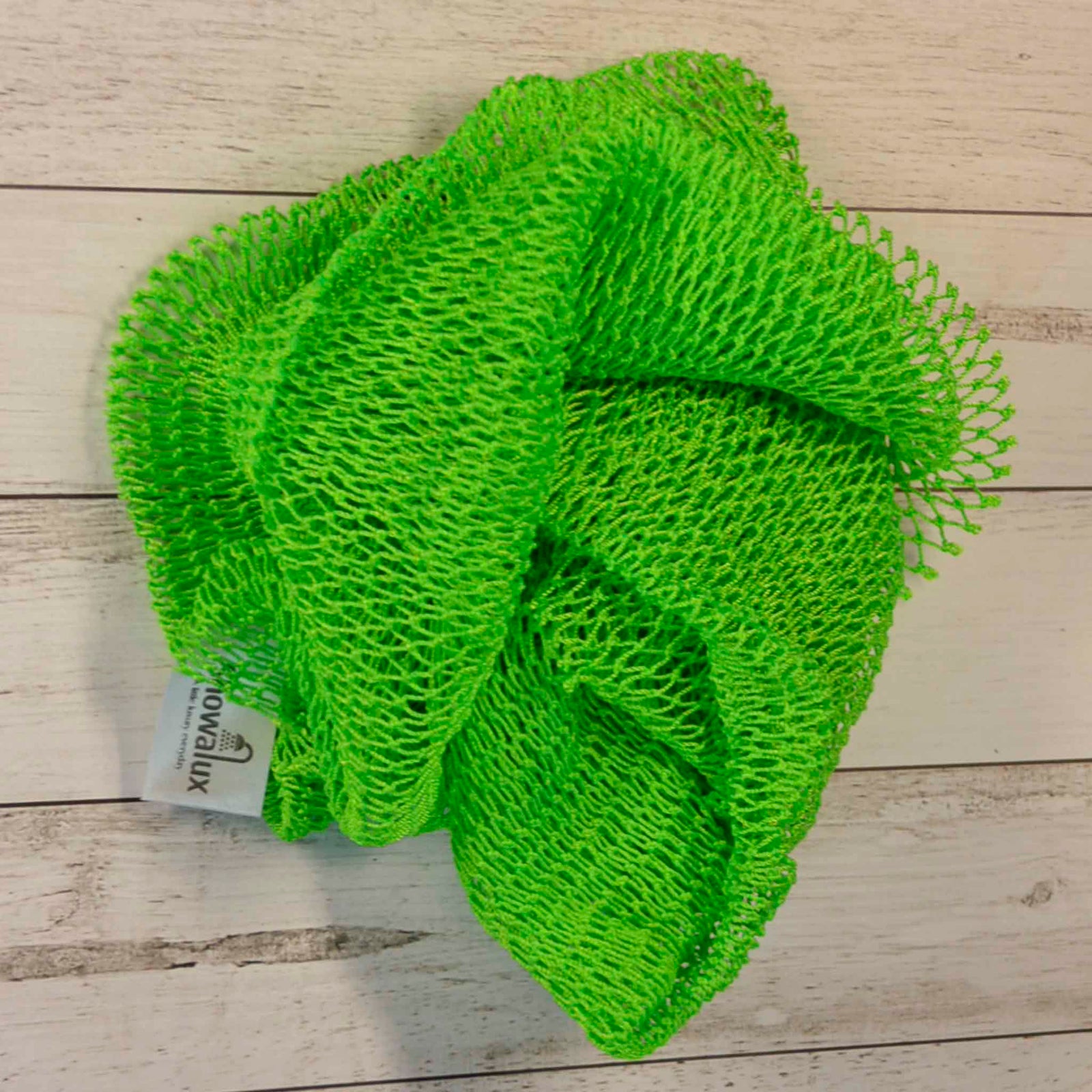 A coil of African Net Sponge coloured Fluro Green on a white background