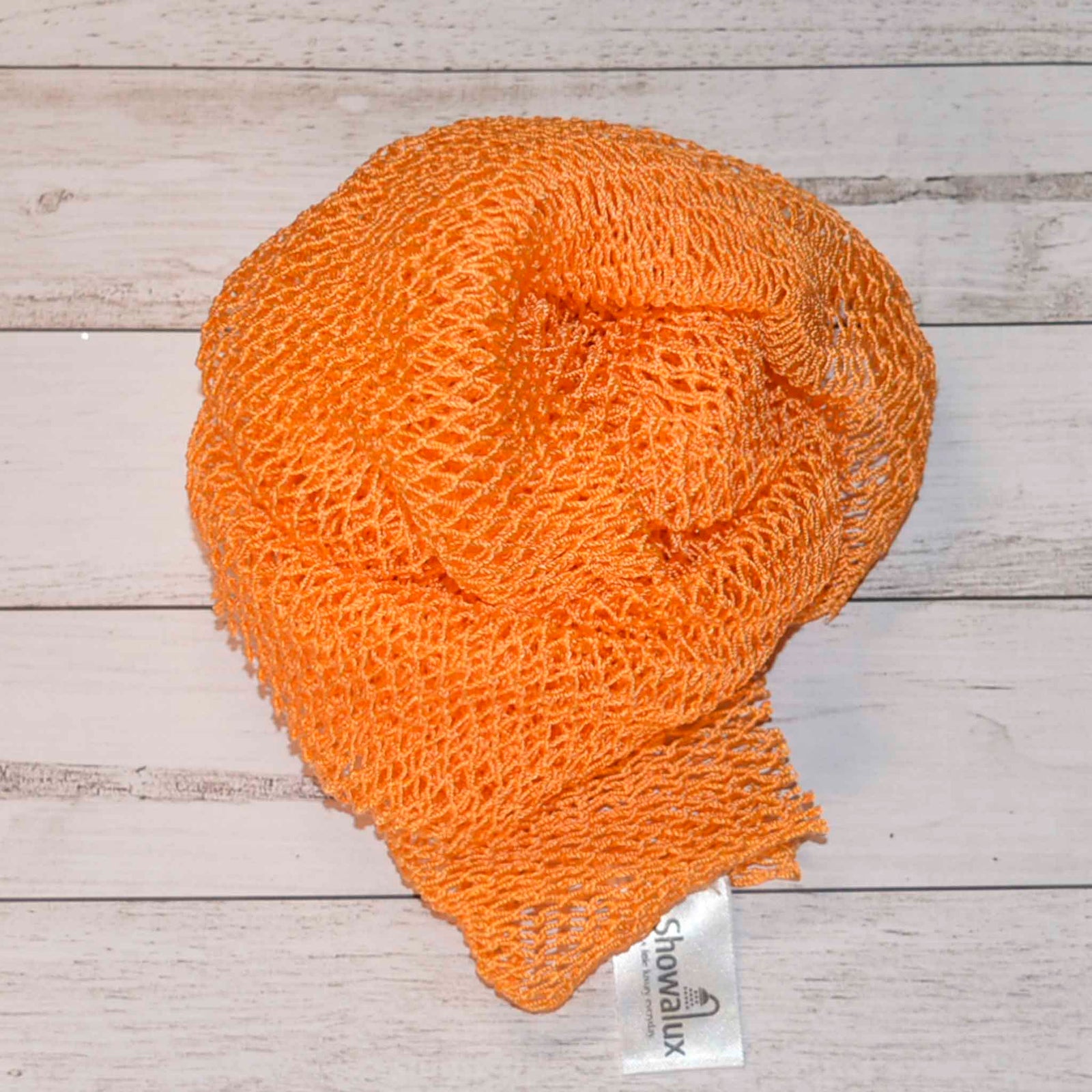 A coil of African Net Sponge coloured Orange on a white background