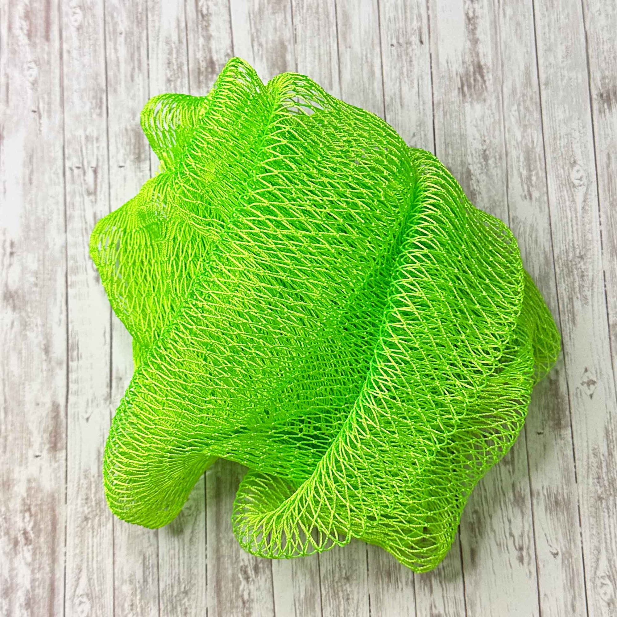 A coil of African Net Sponge coloured Fluro Green on a white background