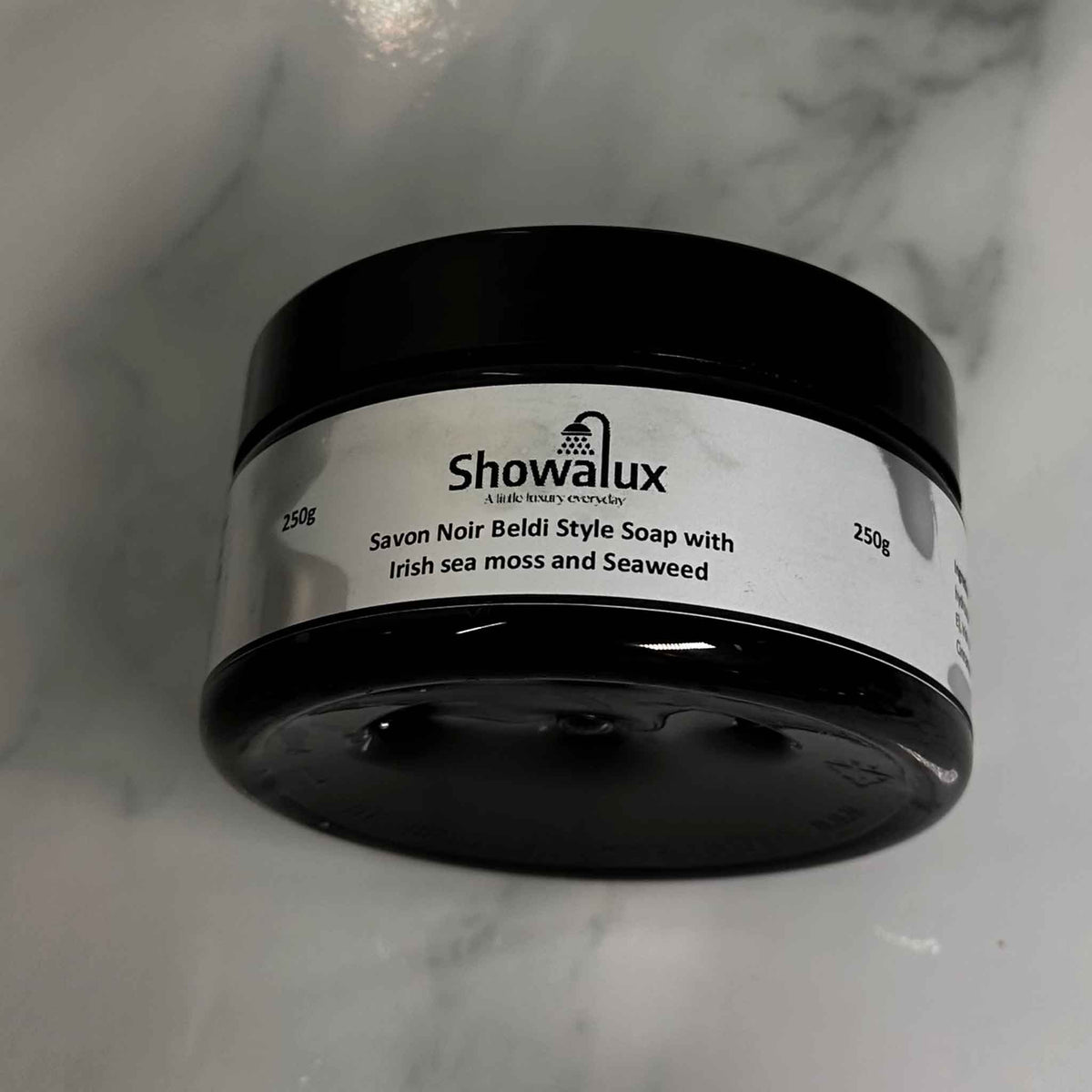 Side view of Beldi Soap with Irish Sea Moss and Seaweed in a  jar displaying the name and weight