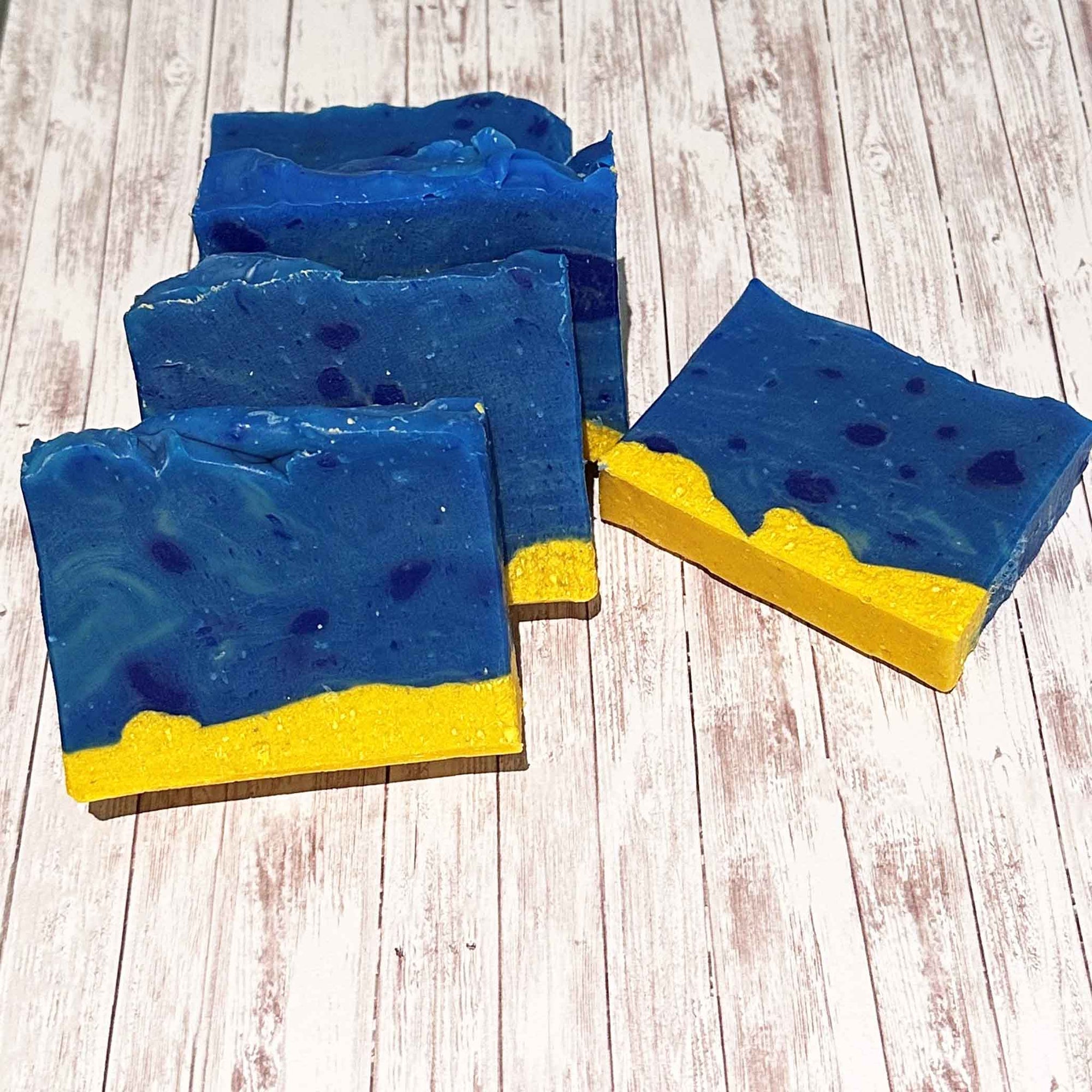 A row of Showalux blue and yellow soaps, and one soap laying flat on a white wash background