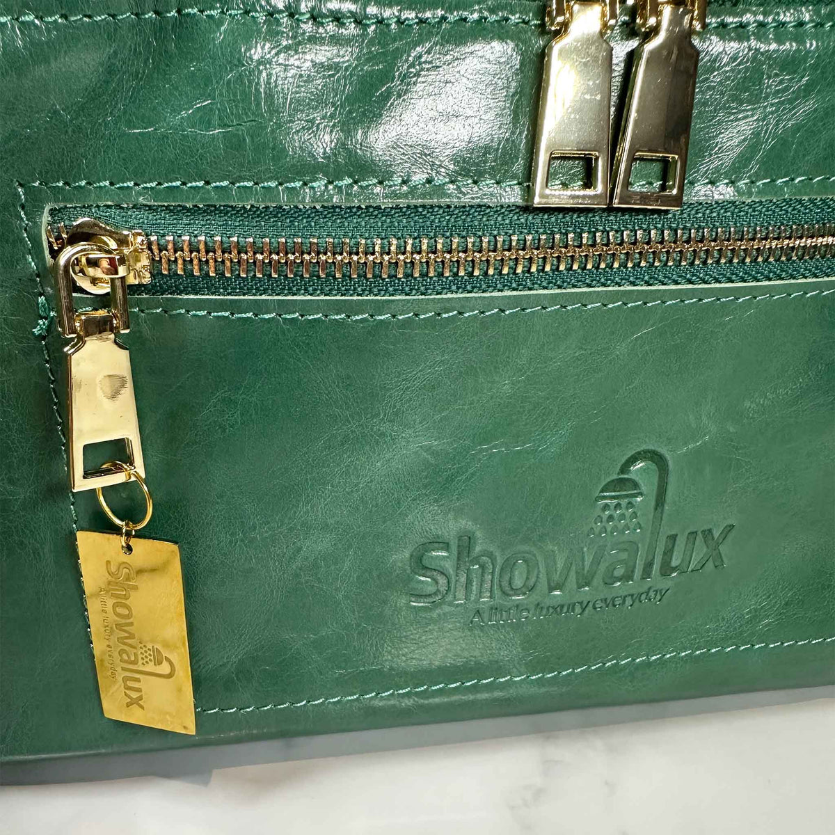 Green leather bag with gold zipper and Showalux logo on a white background