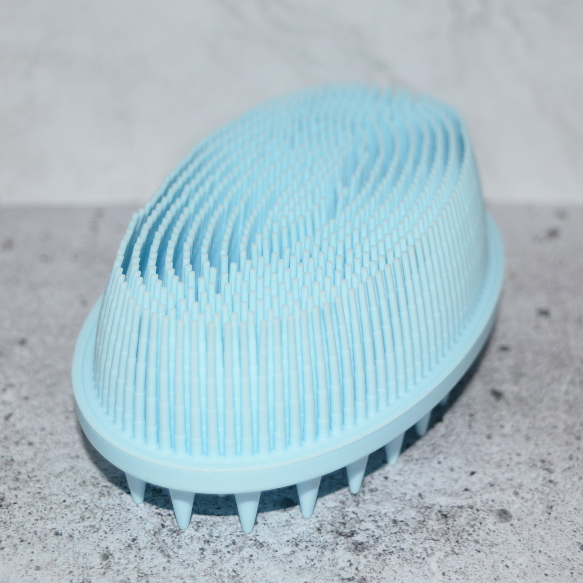 Light Blue soft silicone scrub brush with very soft fine bristles on one side, and short firm nubs on the other side
