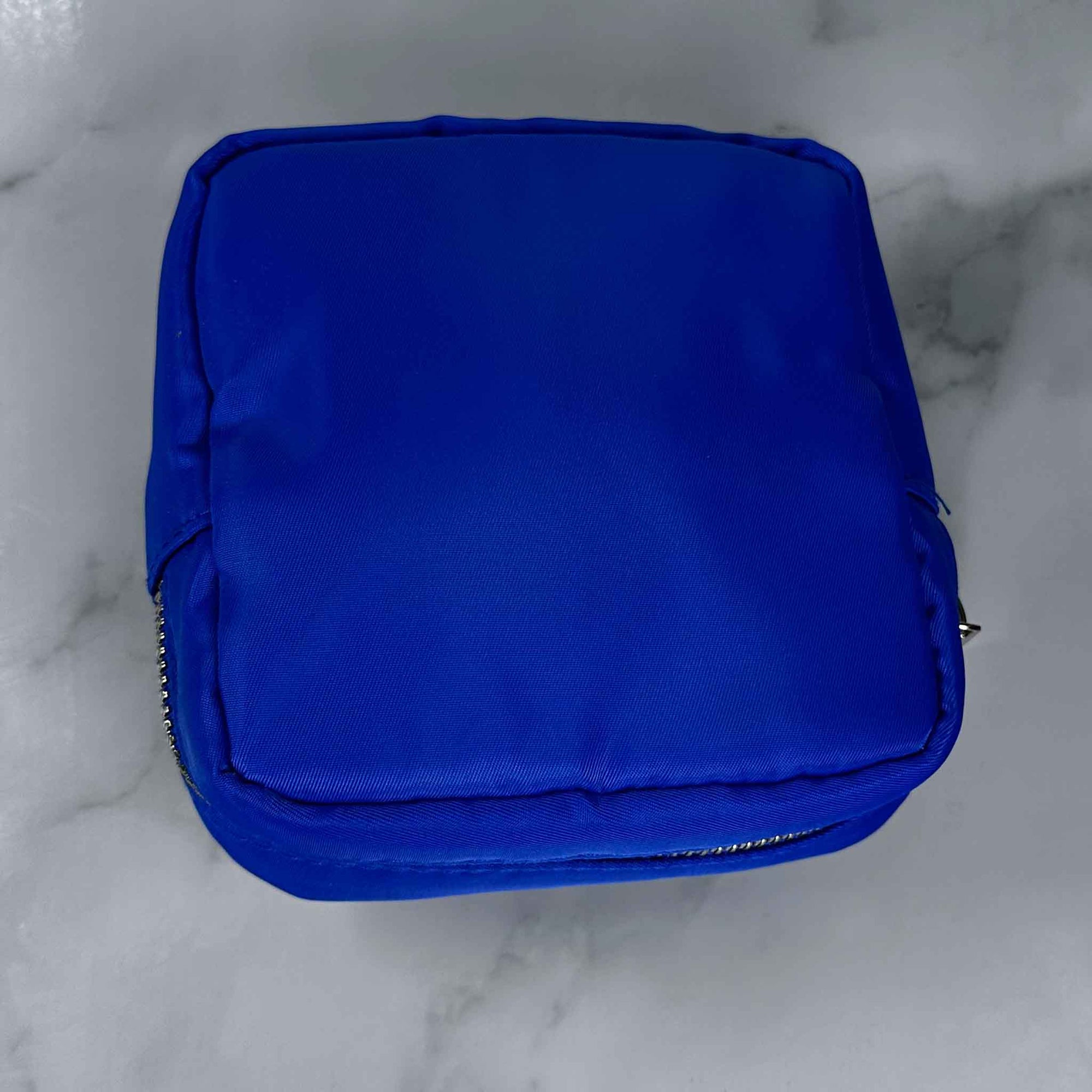 Bright Blue Showalux personal bag on a marble surface