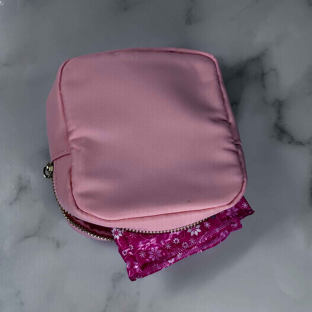 Pink satin Showalux pouch showing interior on a marble surface