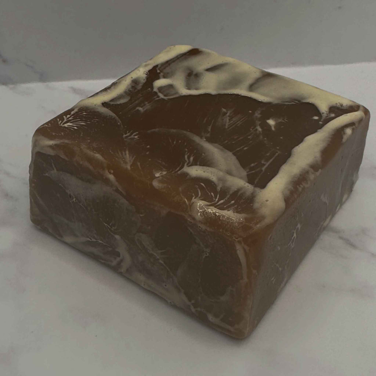 A bar of brown soap with generated lather