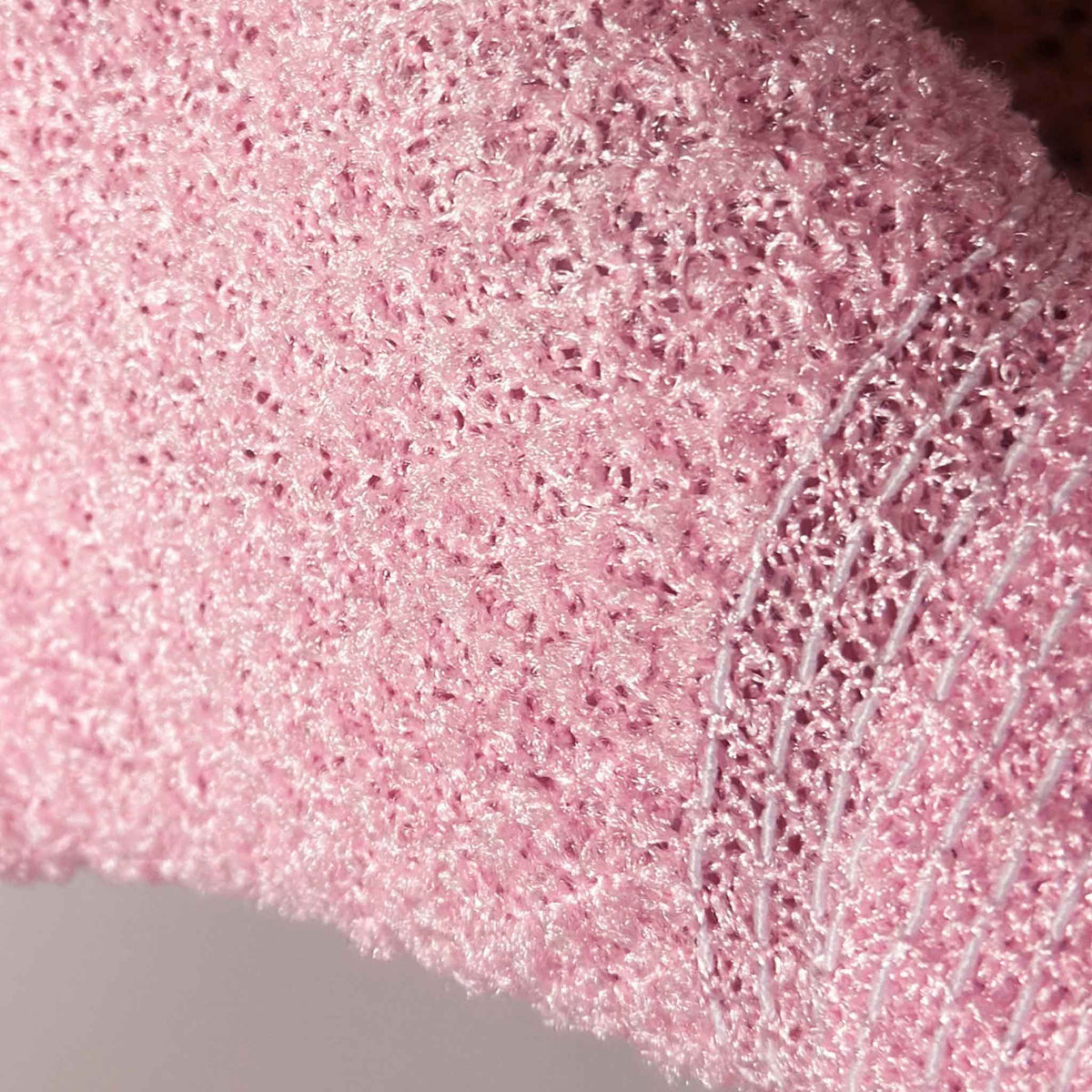 Close up picture of pink exfoliating glove showing texture