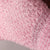 A pair of baby blue exfoliating gloves, with a pair of baby pink exfoliating gloves on a white textured background