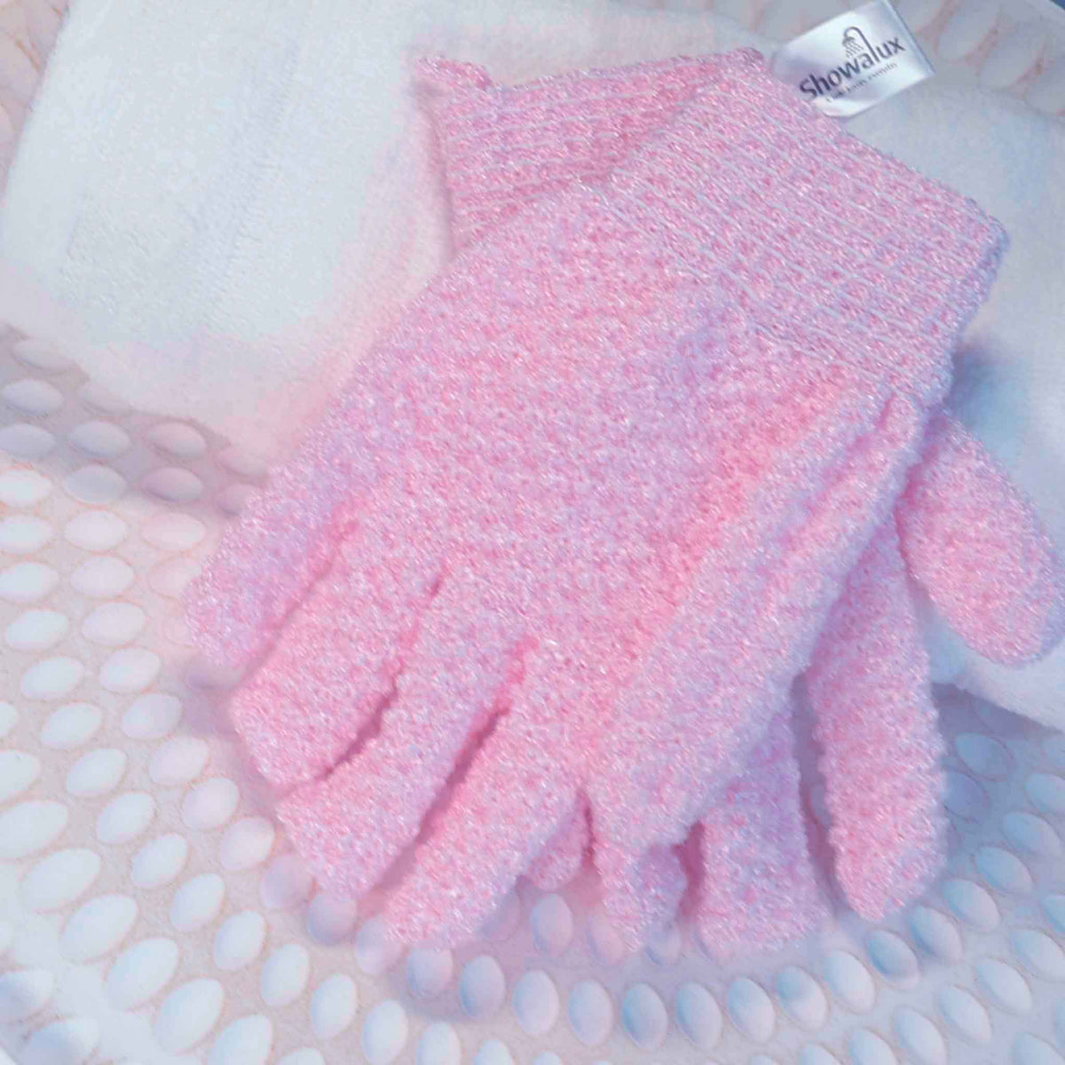 A pair of baby pink exfoliating gloves