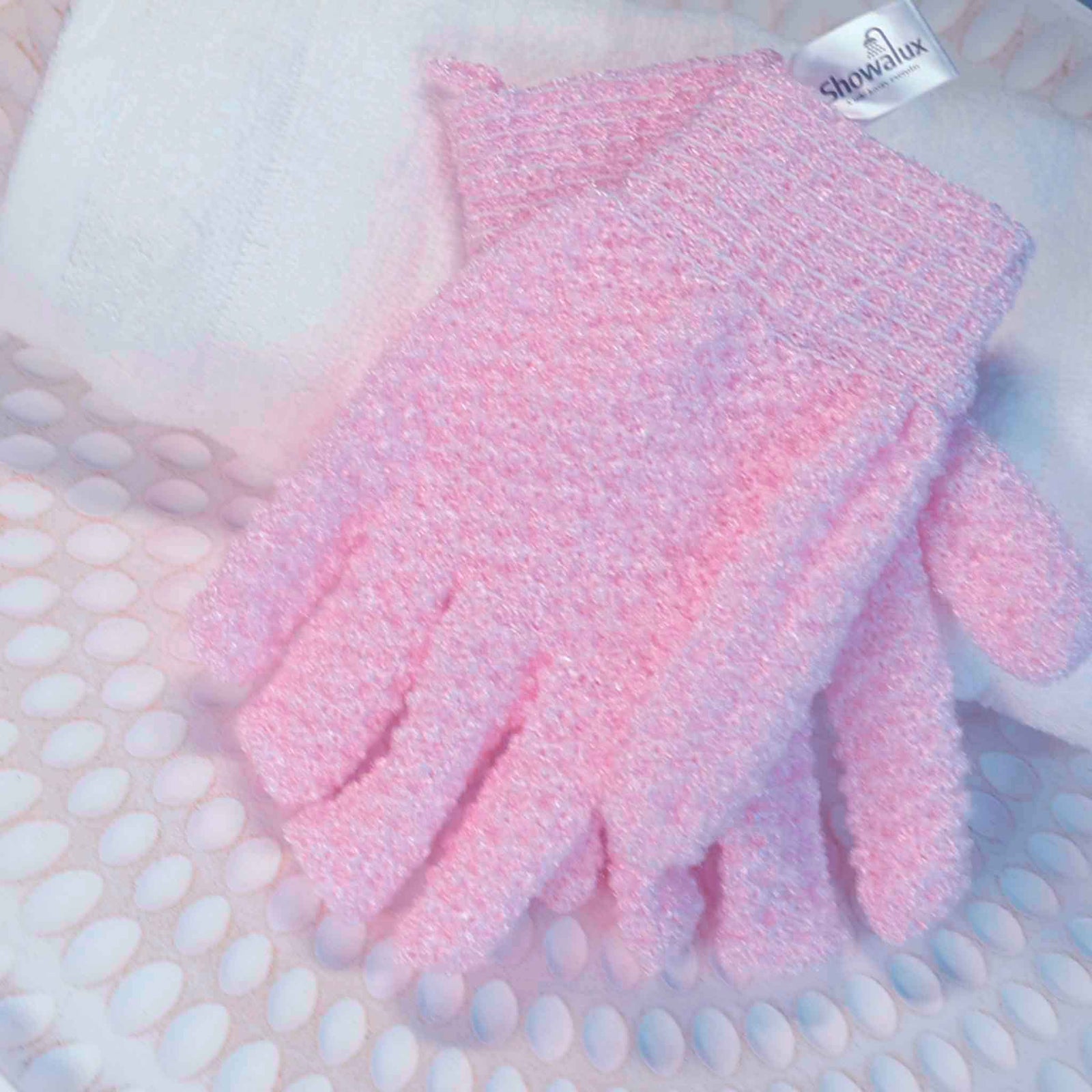 A pair of baby pink exfoliating gloves