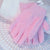 A pair of baby pink exfoliating gloves