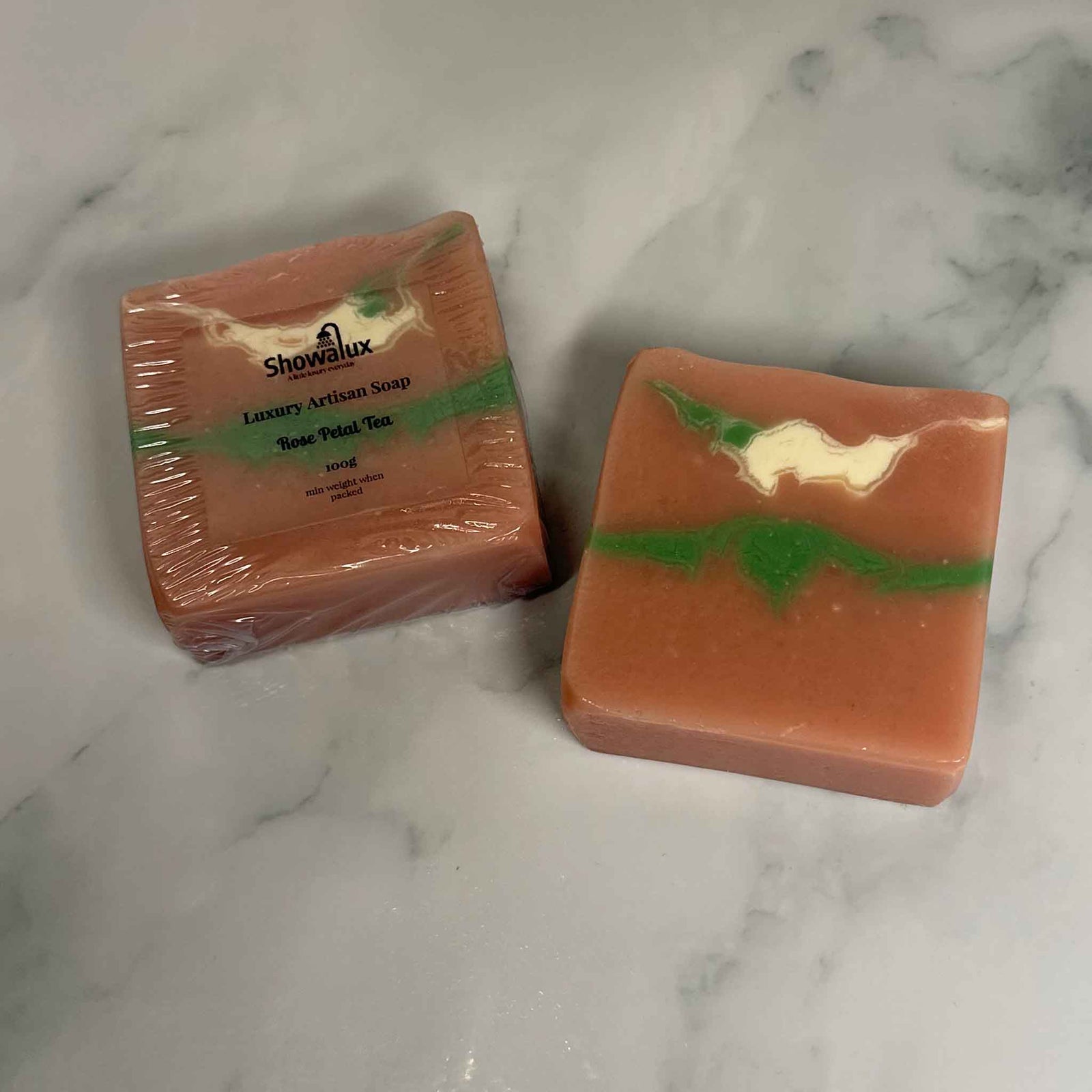 Two bars of Showlux soap on a marble surface