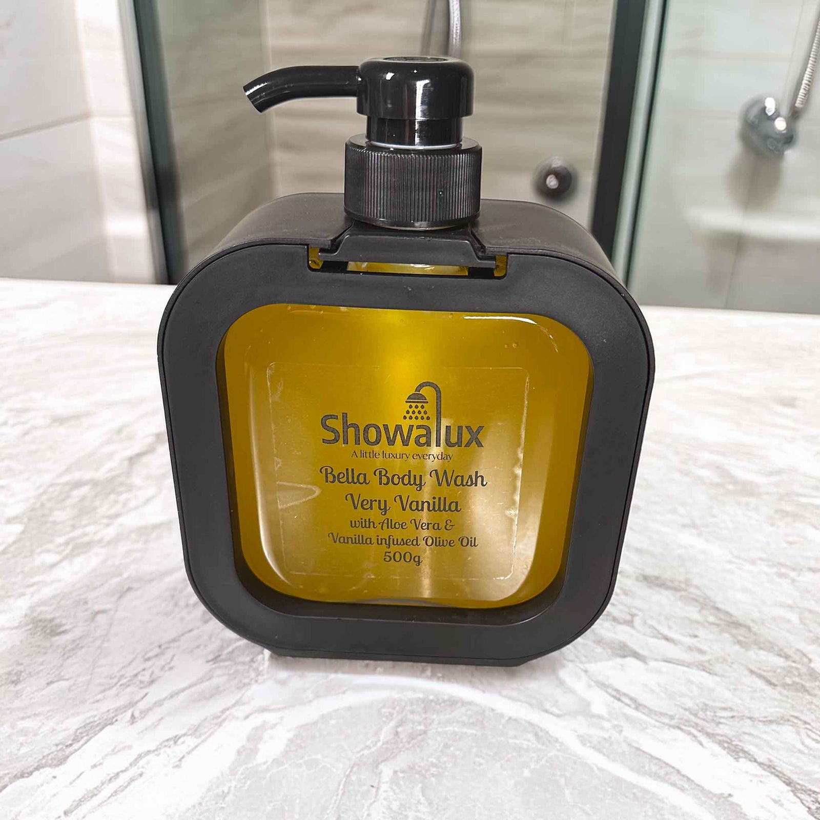 Showalux Bella Body Wash bottle with pomegranate seeds on a bathroom counter