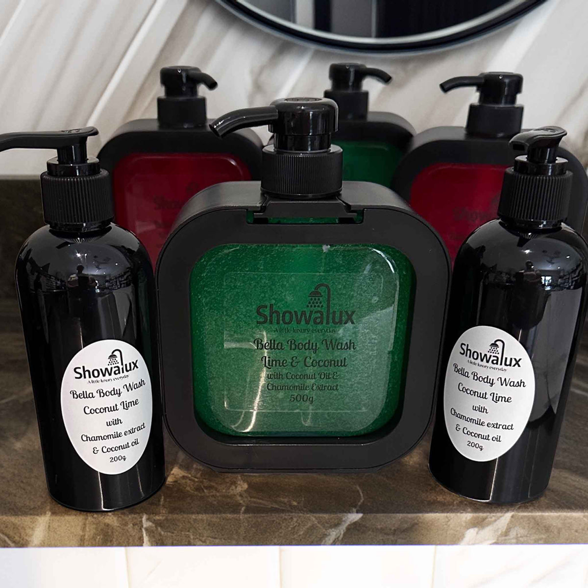 Showalux Bella Body Wash bottles with a green soap on a marble surface.