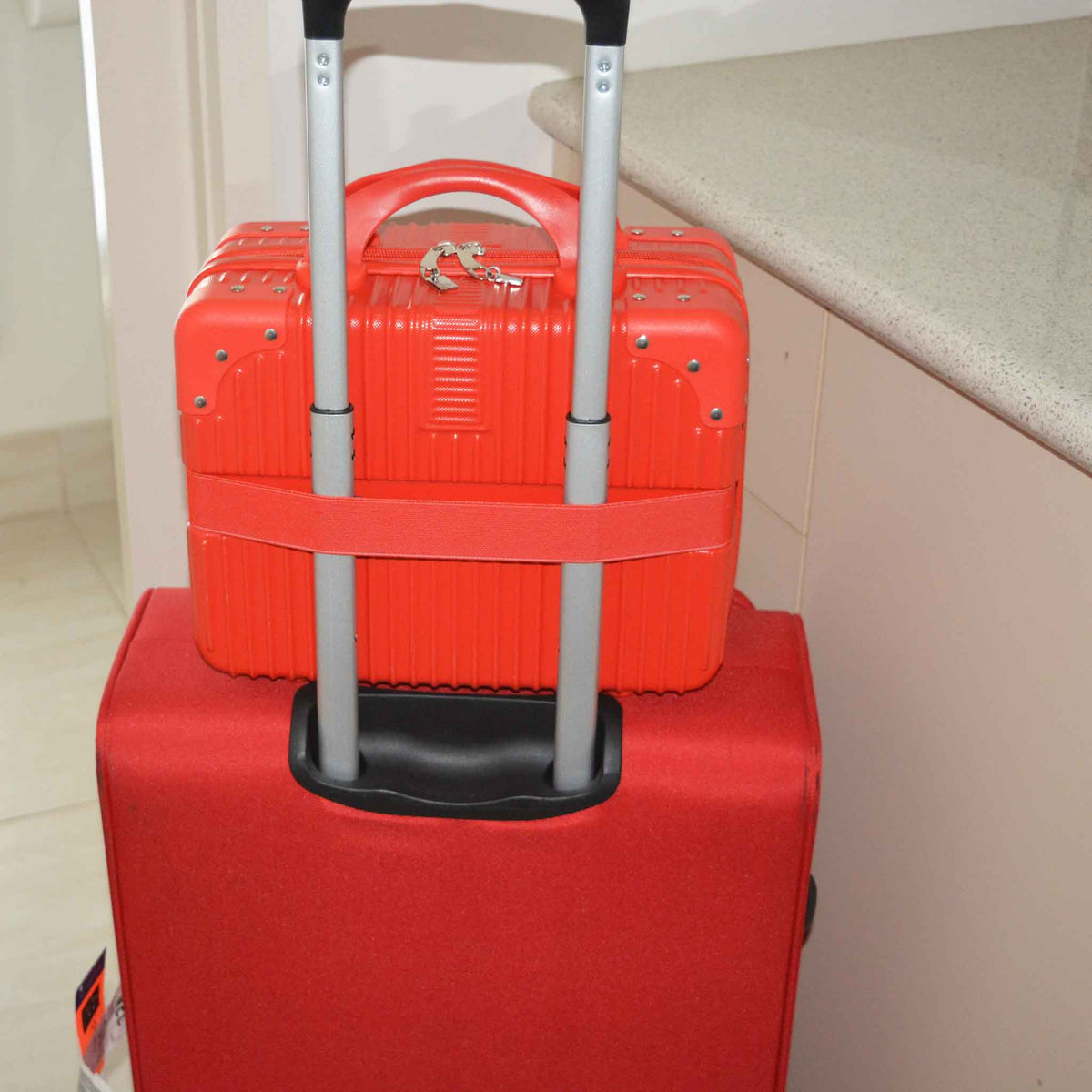 Suitcase Style Toiletry Bag with elastic strap over a handle of a large suitcase