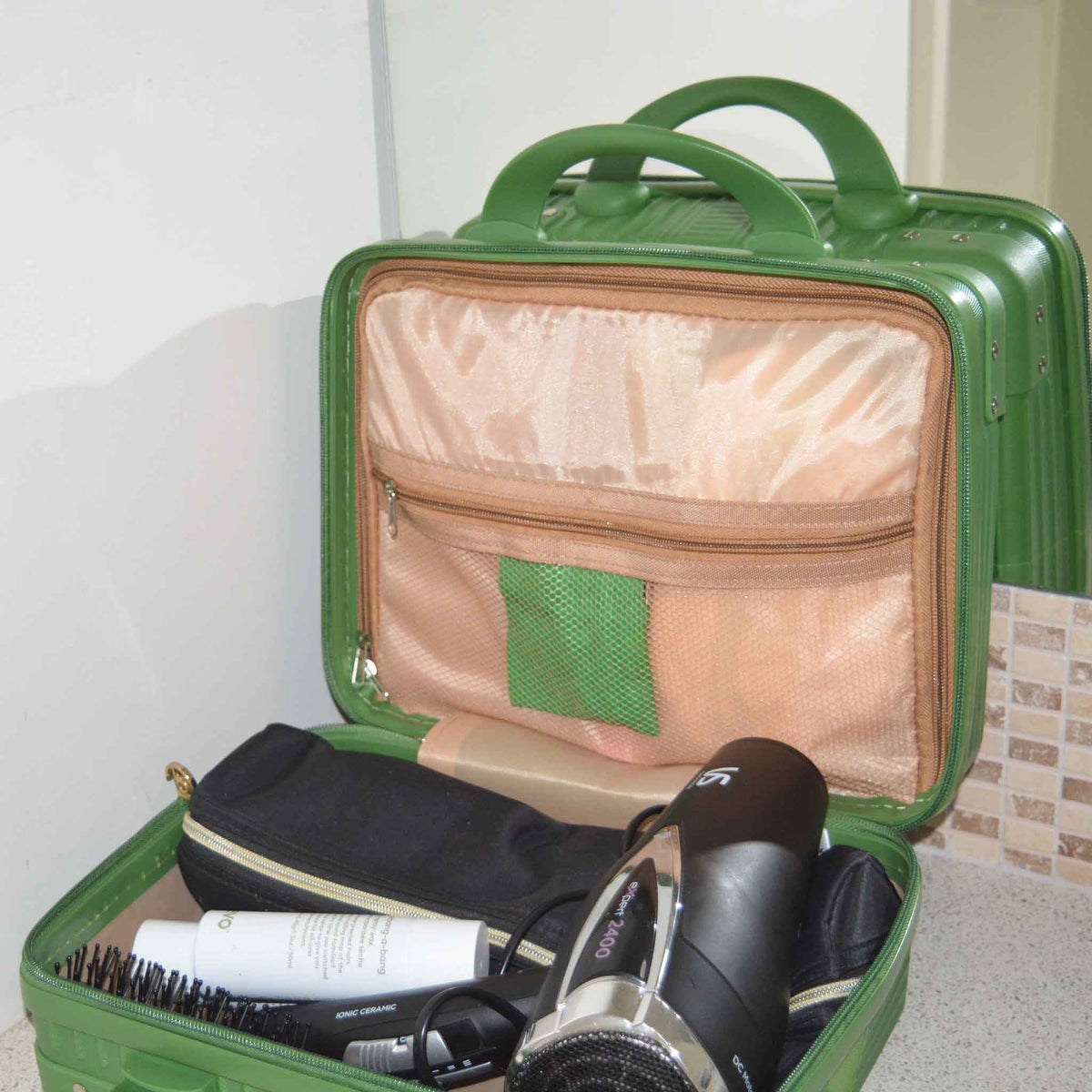 Green Suitcase style bag on a bench, open showing hair equipment