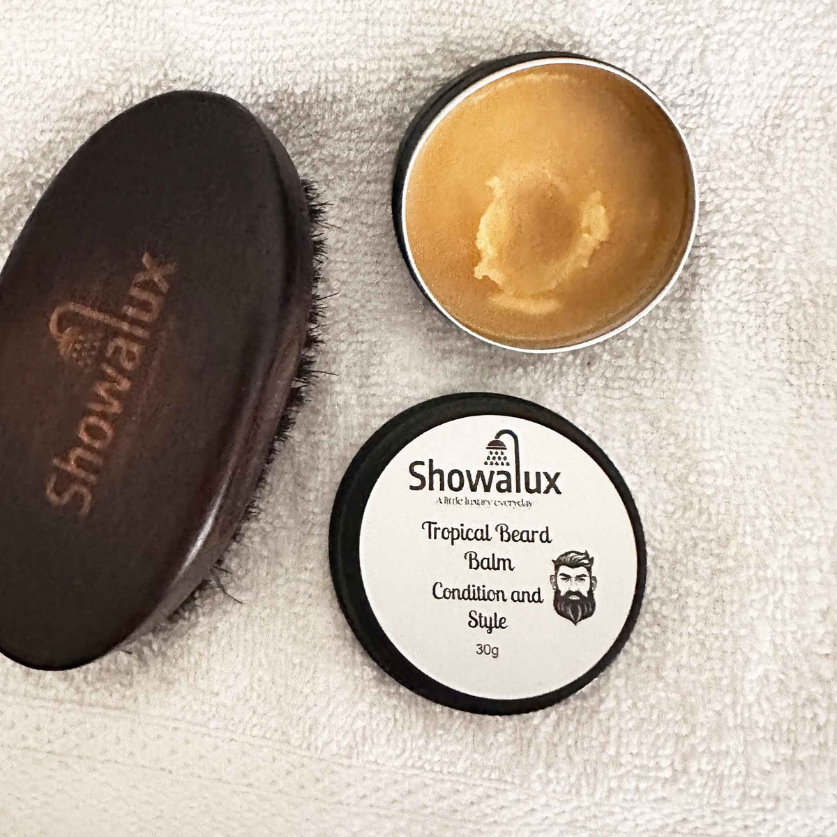 Showalux tropical beard balm and brush on a textured surface