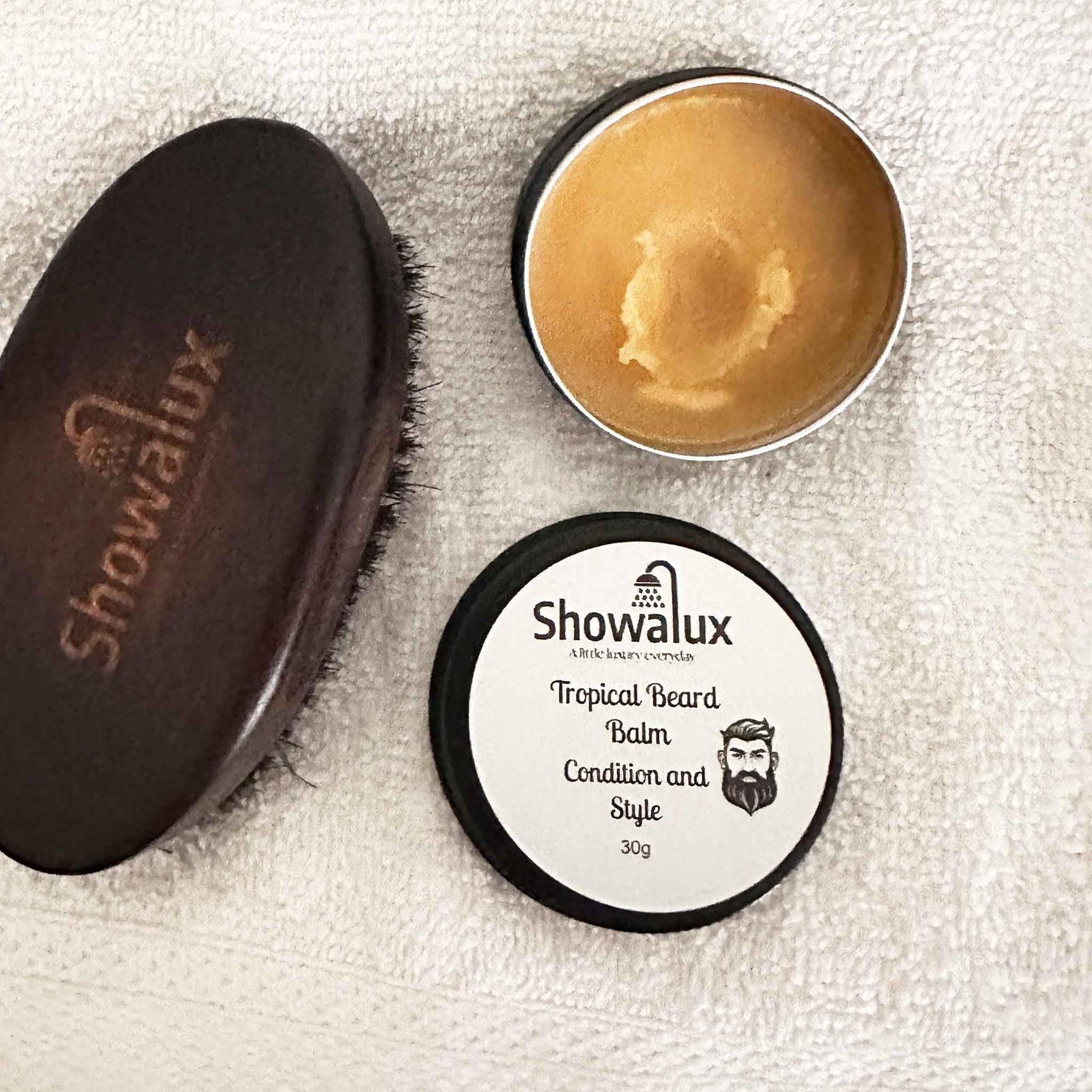 Showalux tropical beard balm and brush on a textured surface
