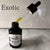 Gold oil spilled on a counter top with a black bottle and eye droppr