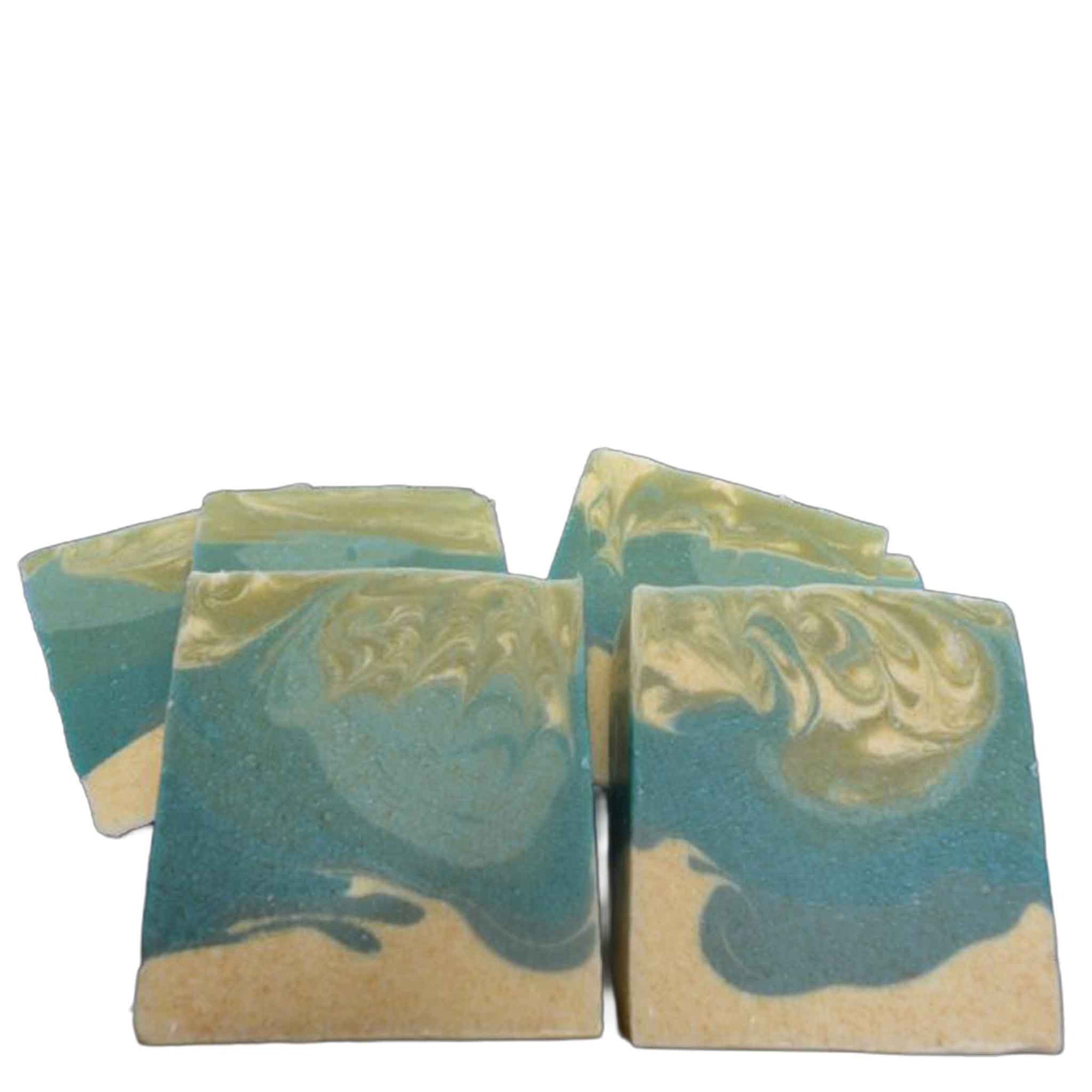 2 soap bars coloured blue, green and cream, one with a label,  on a marble background