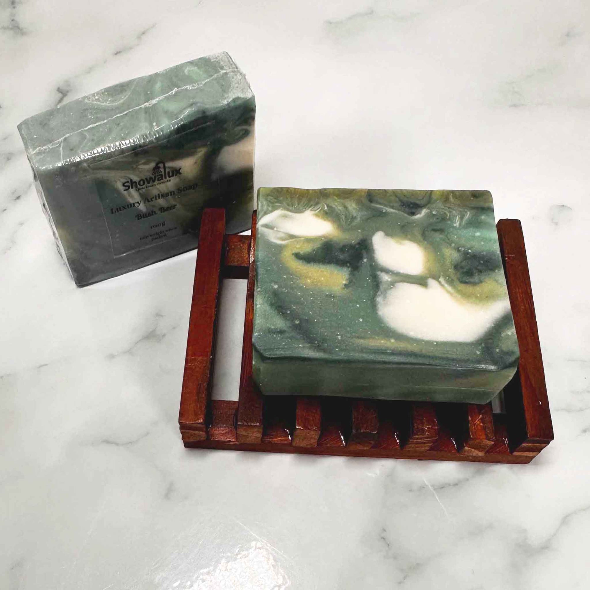 2 bars of green swirled with white soap on a slatted soap dish