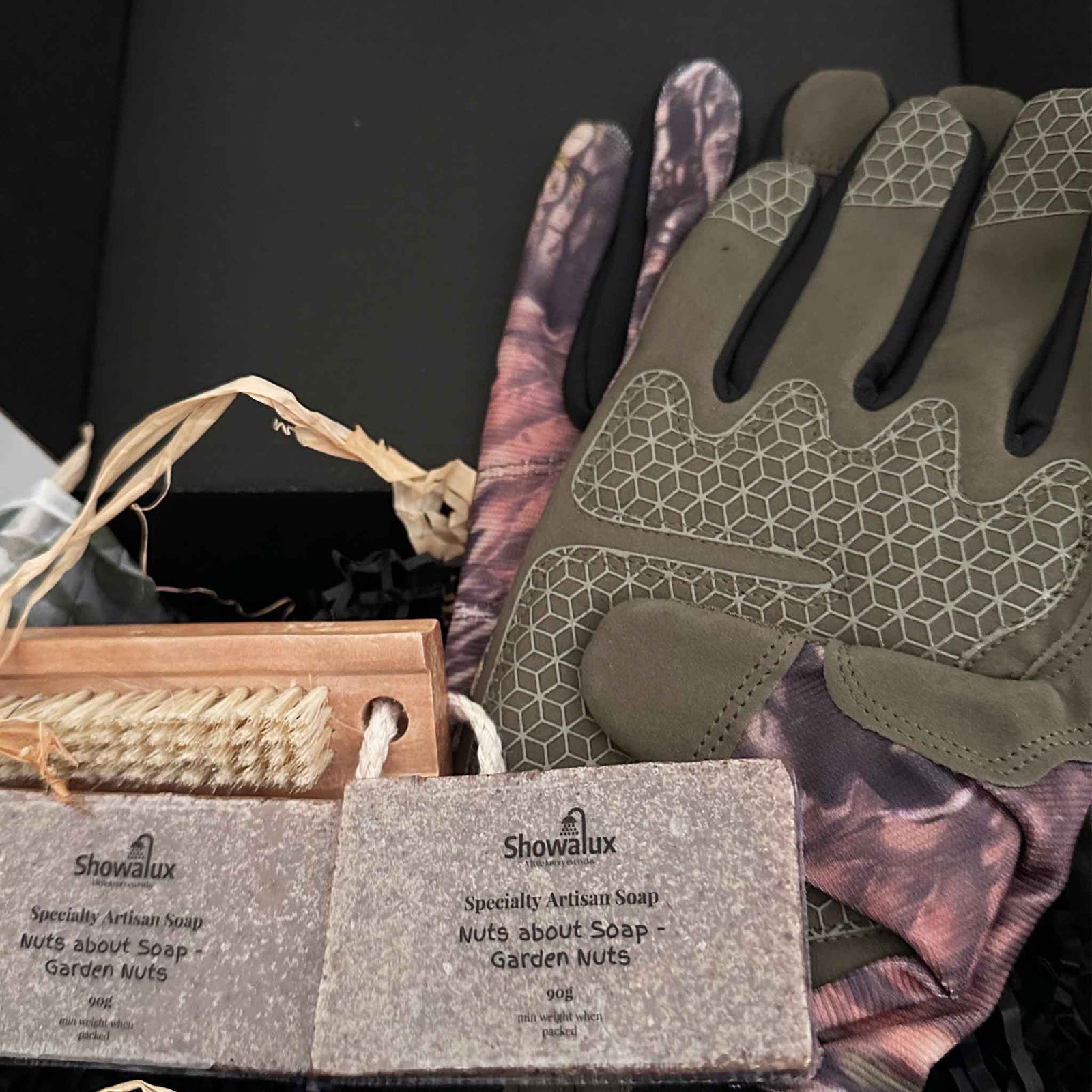 Showalux soap and gardening gloves with a black background