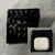 Black woven Showalux pouch with a white air pod case on a marble surface