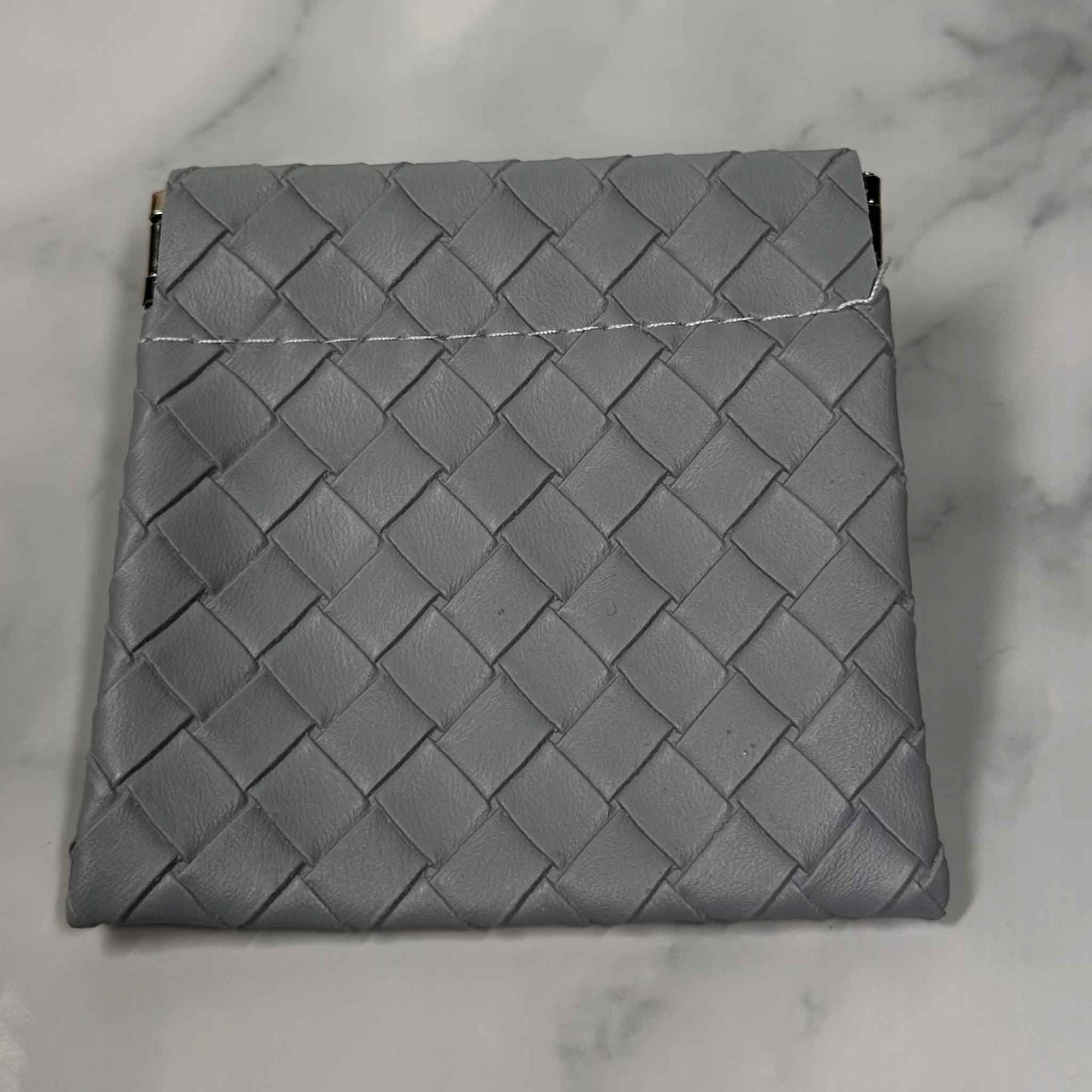 Gray woven Showalux personal bag on a marble surface
