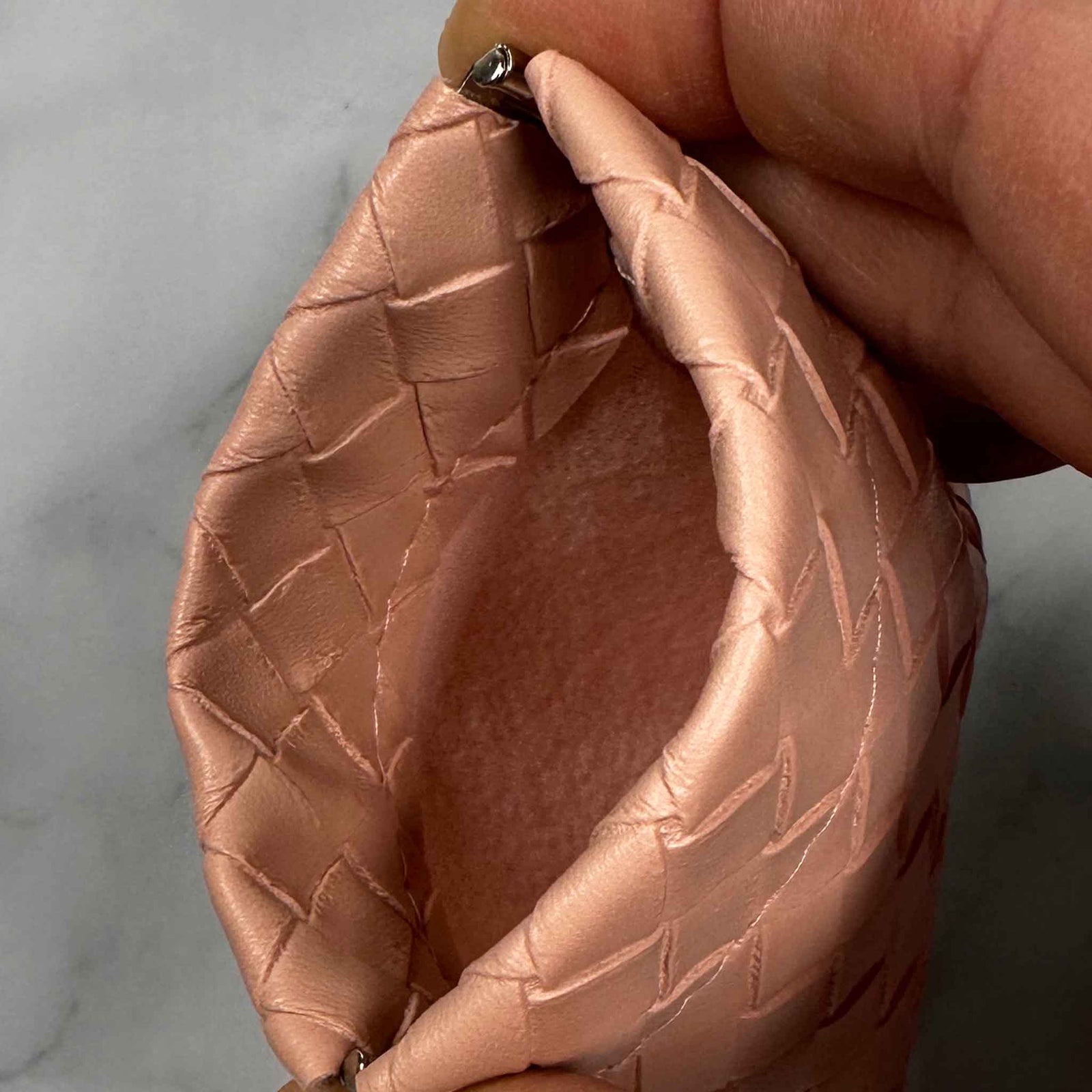 Collection of woven PU leather Showalux personal bags in various colors on a marble surface