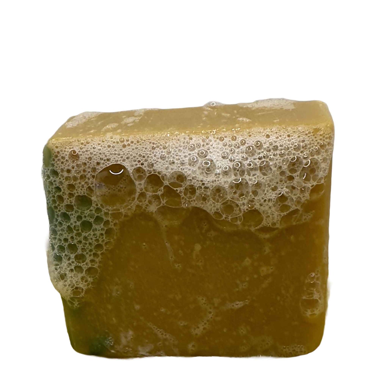 A square cake of soap yellow and green on the side with bubbly lather