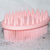 Pink soft silicone scrub brush with very soft fine bristles on one side, and short firm nubs on the other side